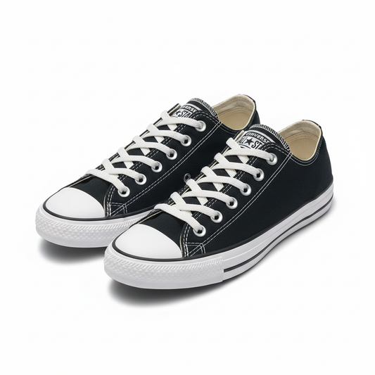Black Converse Chuck Taylor low-top sneakers in a front side angle on white background